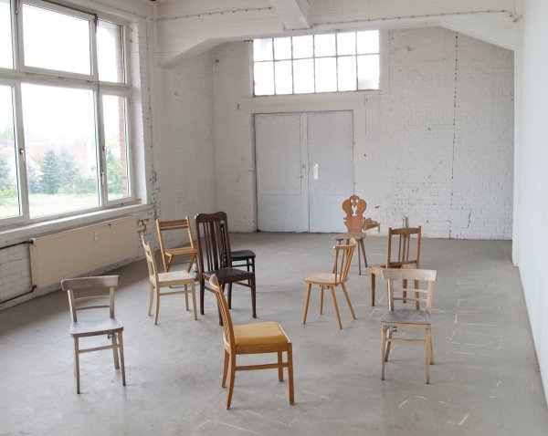 Artur Niestroj – Bez názvu, 2012, deset běžných židlí s časovačem a vibračními motory,  Salzmannfabrik Kassel